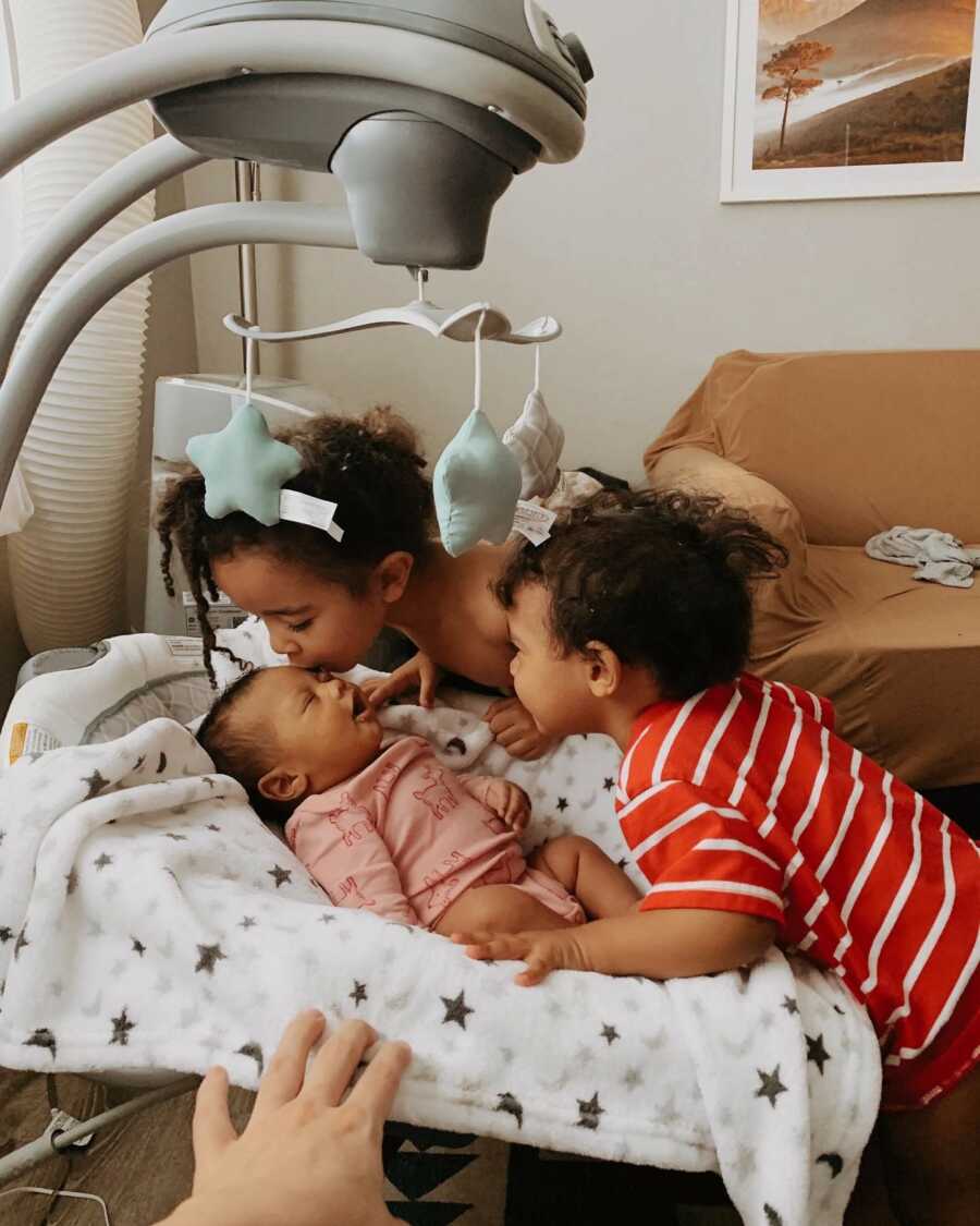 kids kissing their new sibling