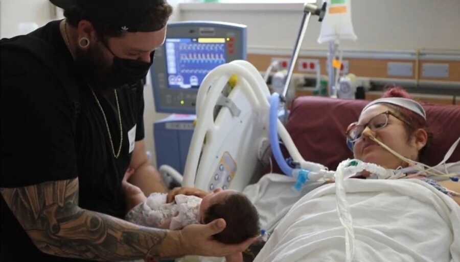 dad introducing baby to mom after she has been battling COVID