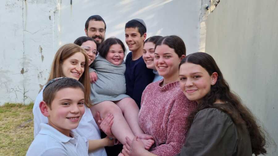 little girl being held up by her siblings