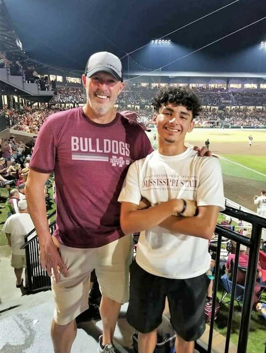 Single dad and adoptive attend at at baseball stadium attending a baseball game wearing a Bulldogs shirt and a Mississippi State Shirt 