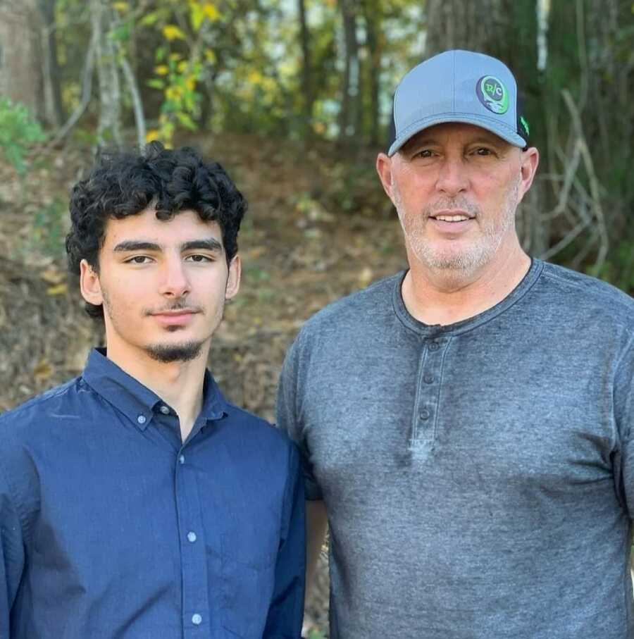 Single dad and adoptive son in the forest wearing blue shirts 