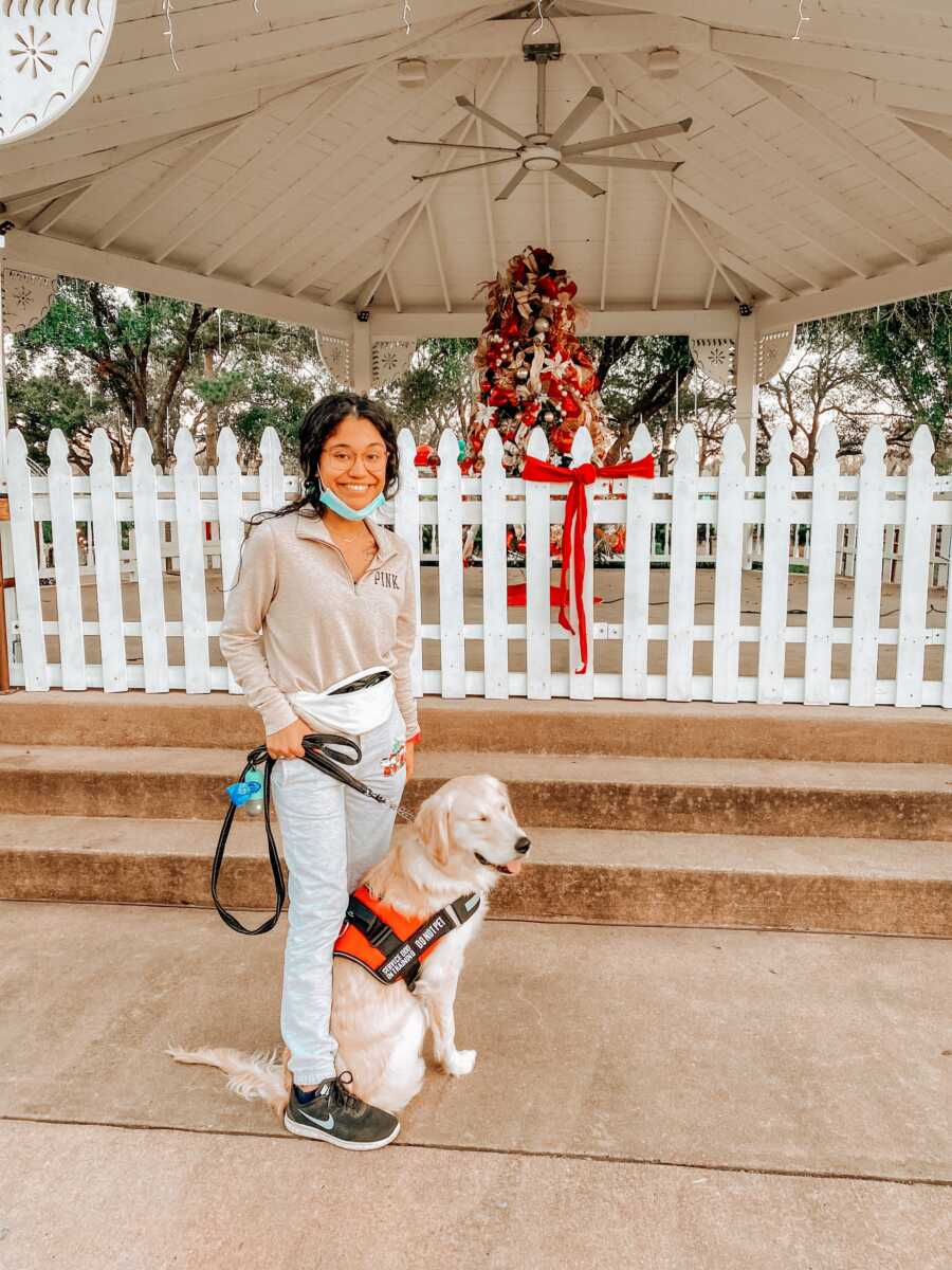 Young woman with mental illnesses takes a photo with her young service dog in training
