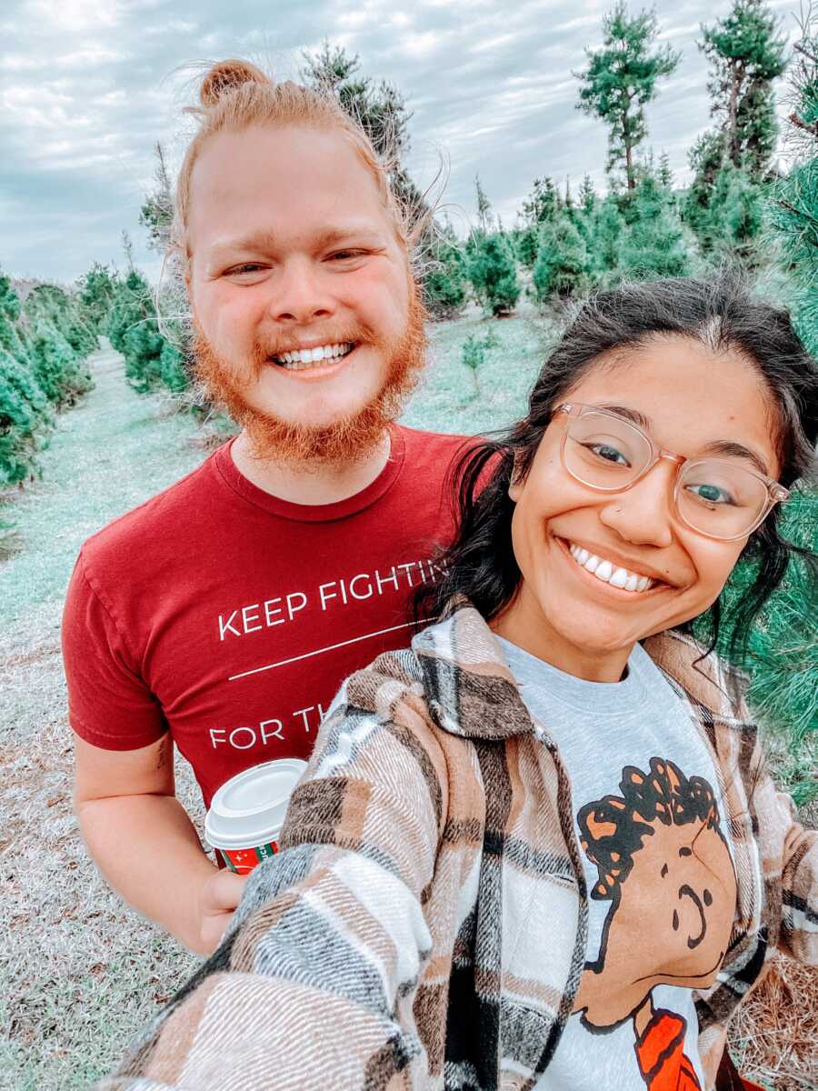 Young married couple take a selfie at a Christmas tree farm