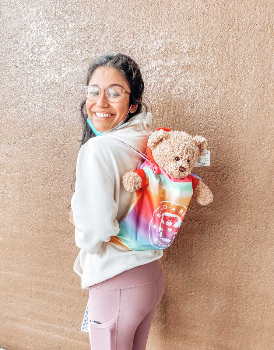 Young woman healing her inner child takes a photo with a build-a-bear