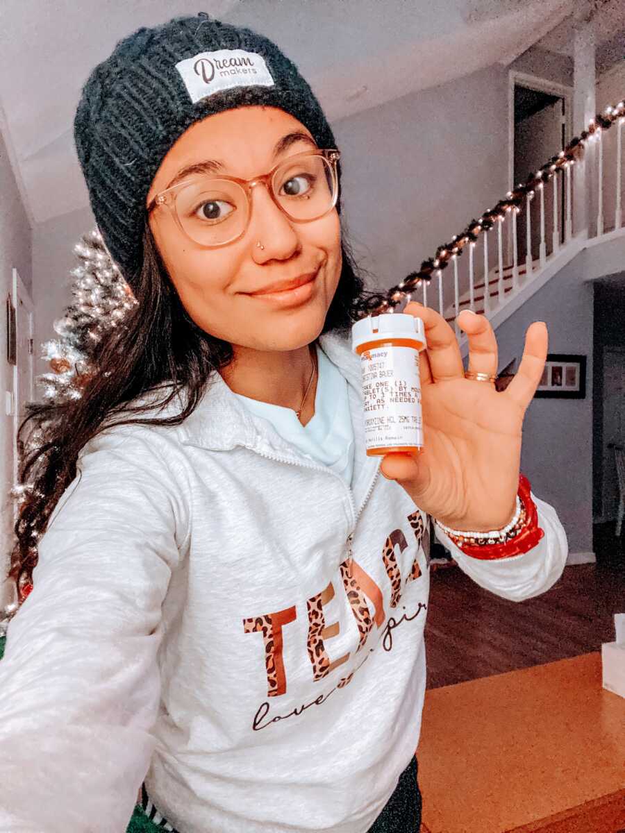Woman healing her childhood trauma takes a photo with a prescription bottle