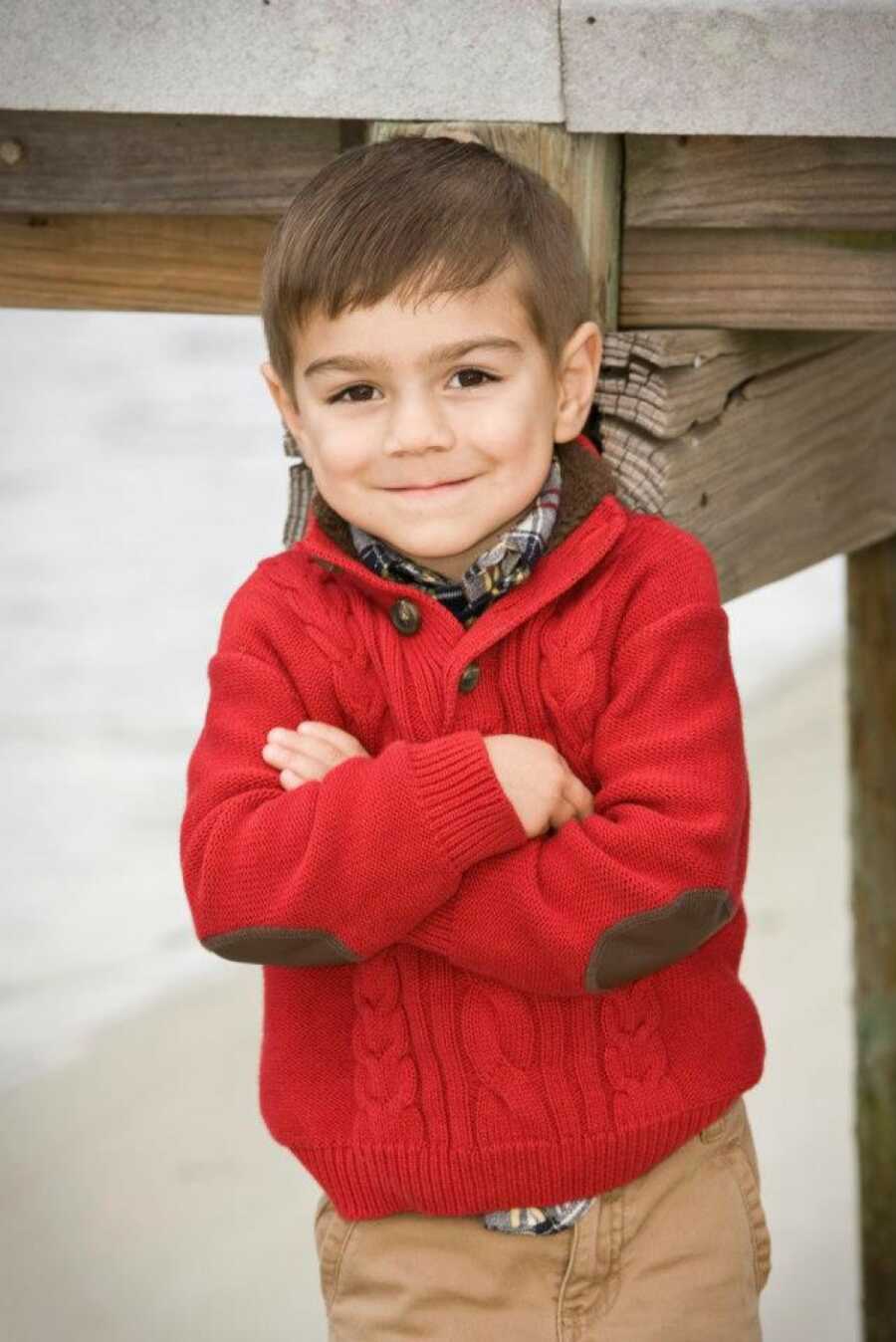 adopted son standing in a red coat smiling