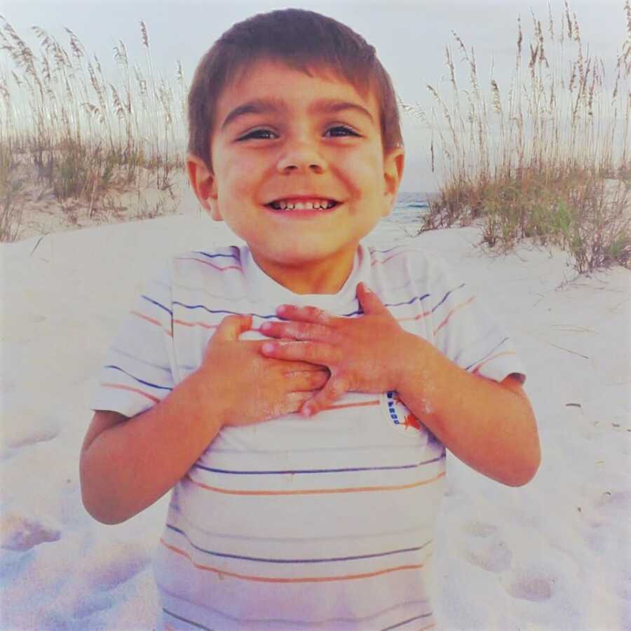 adopted son as a kid smiling on the beach