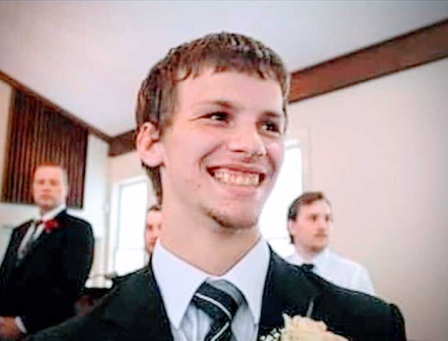 photo of loving brother and son smiling and wearing a suit