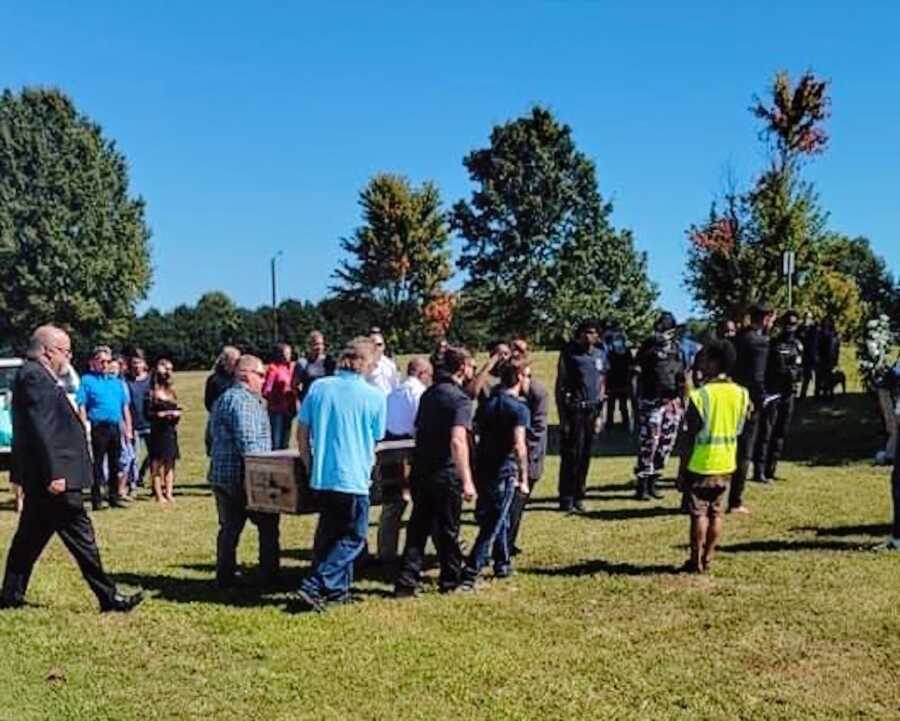 group of men carry the casket of their family member who was fatally shot on the job