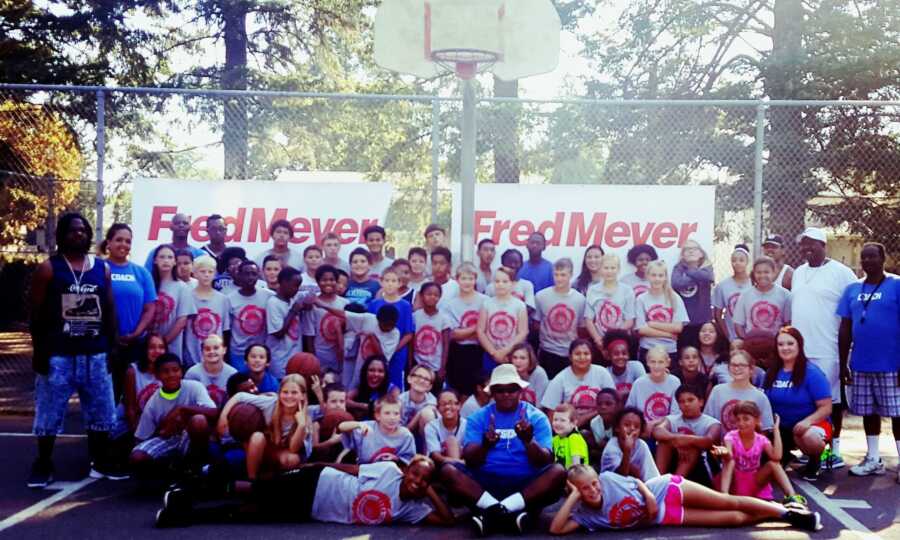 Michael Brown takes a picture with the youth in his basketball camp. 