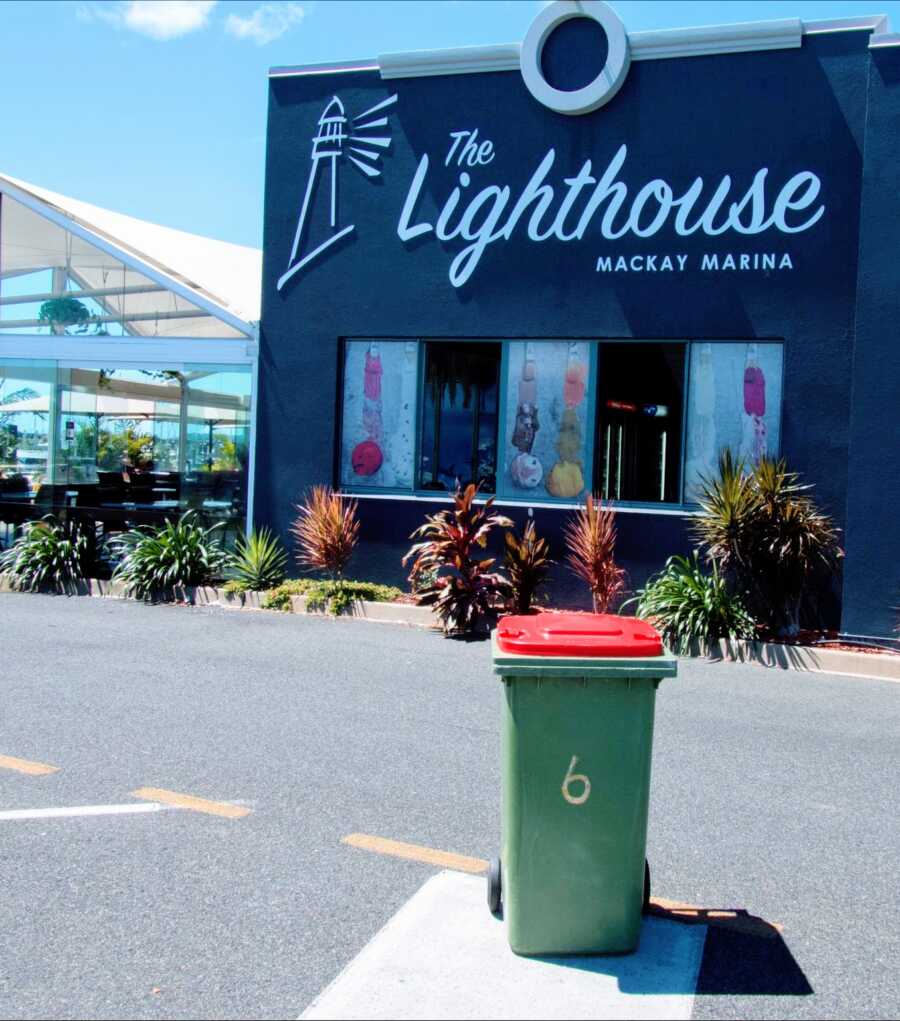 A garbage can takes an adventure and is placed in front of a local restaurant