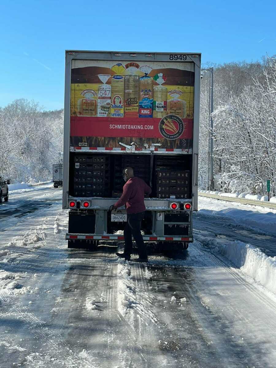 Truck driver, Ron Hill, opens Schmidt Baking Company's truck full of baked goods.