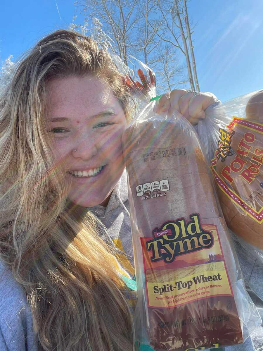 Casey gratefully displays bags of bread after long, hungry night stranded on I-95.