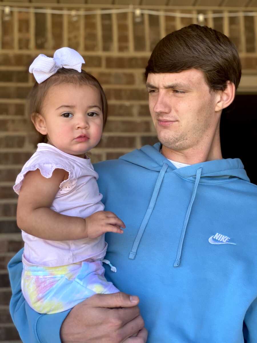 uncle makes funny face while holding little niece