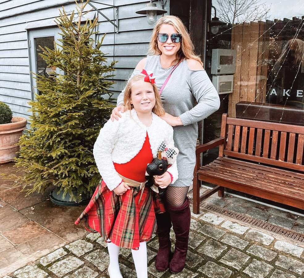 A mom and her daughter standing outside