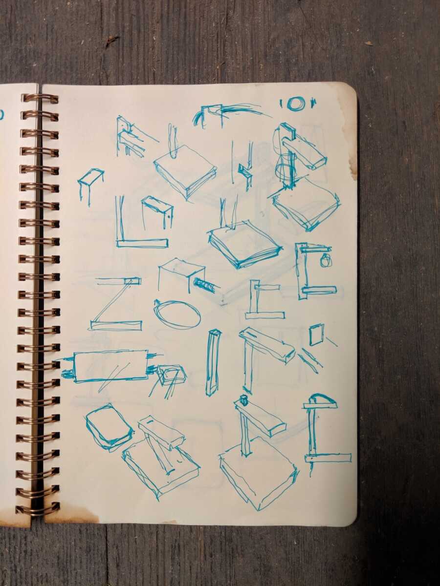 open sketchbook with drawings of furniture designs on page in blue ink