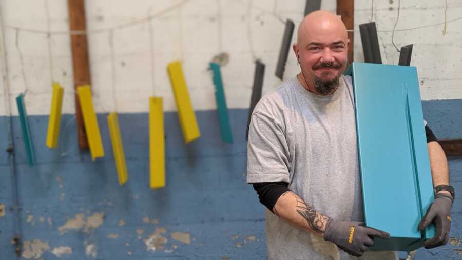 formerly incarcerated employee holding a furniture piece from The Formr