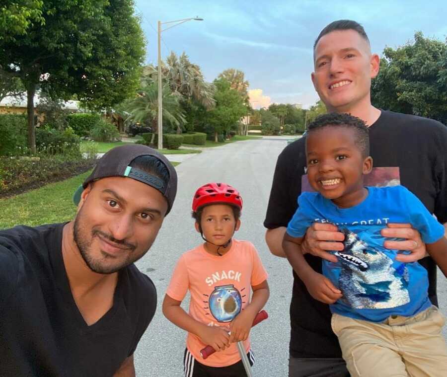 gay dads and their two boys take picture while on nightly walk