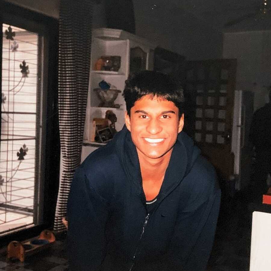 young man takes picture in dark blue zip-up hoodie