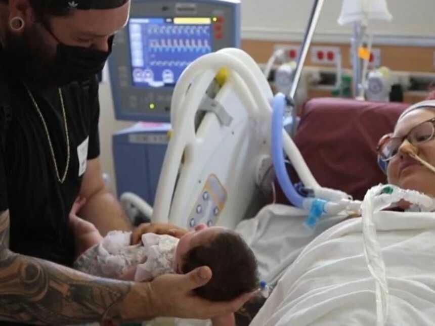 dad introducing baby to mom after she has been battling COVID