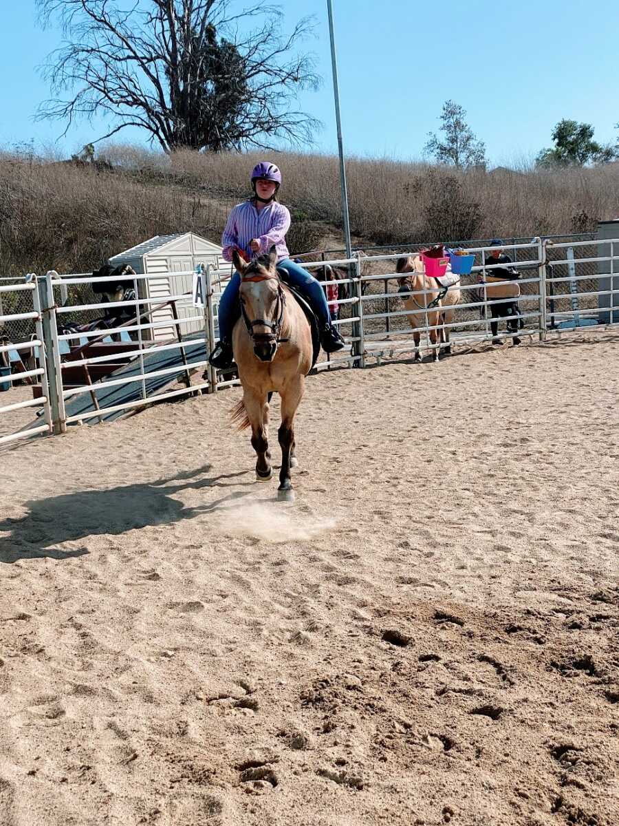 A girl with Down Syndrome riding a horse