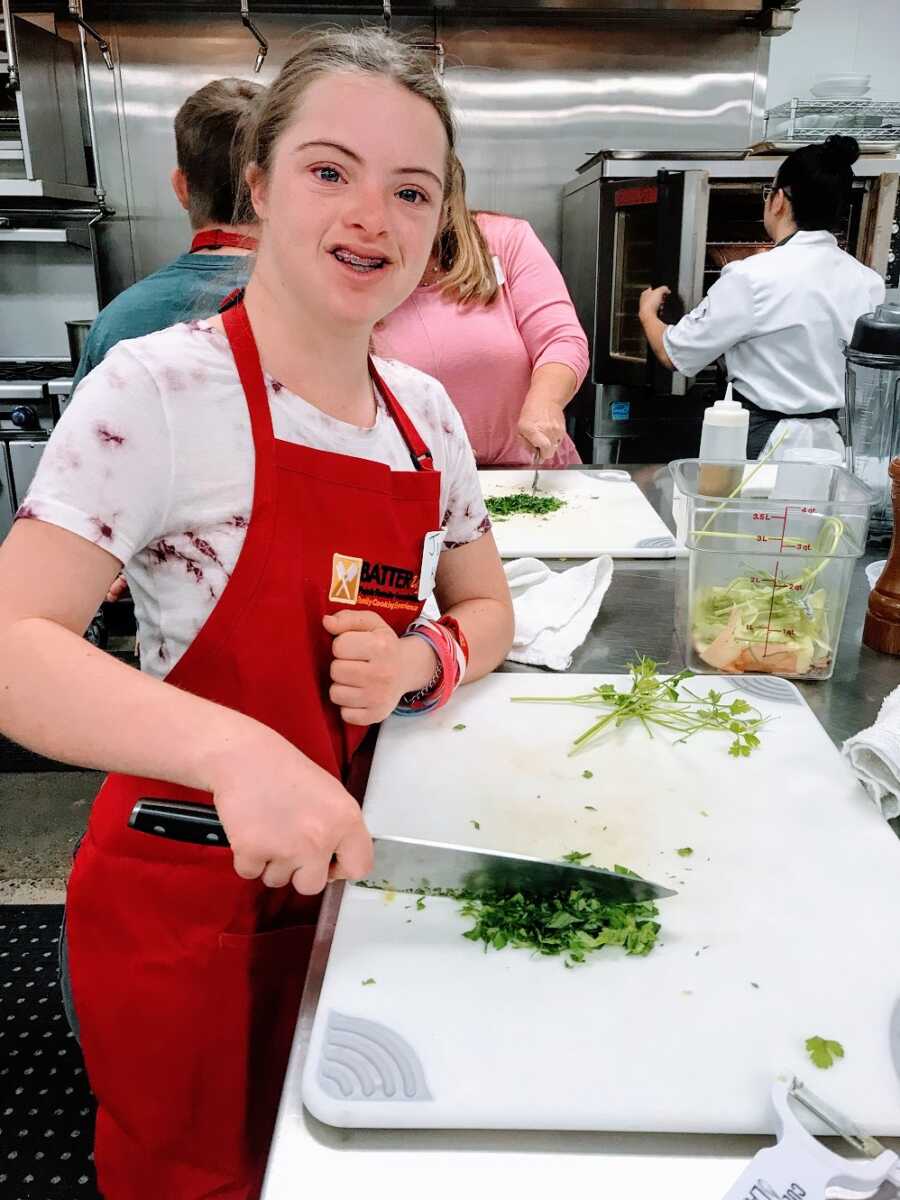 a girl with down syndrome cooking in a kitchen