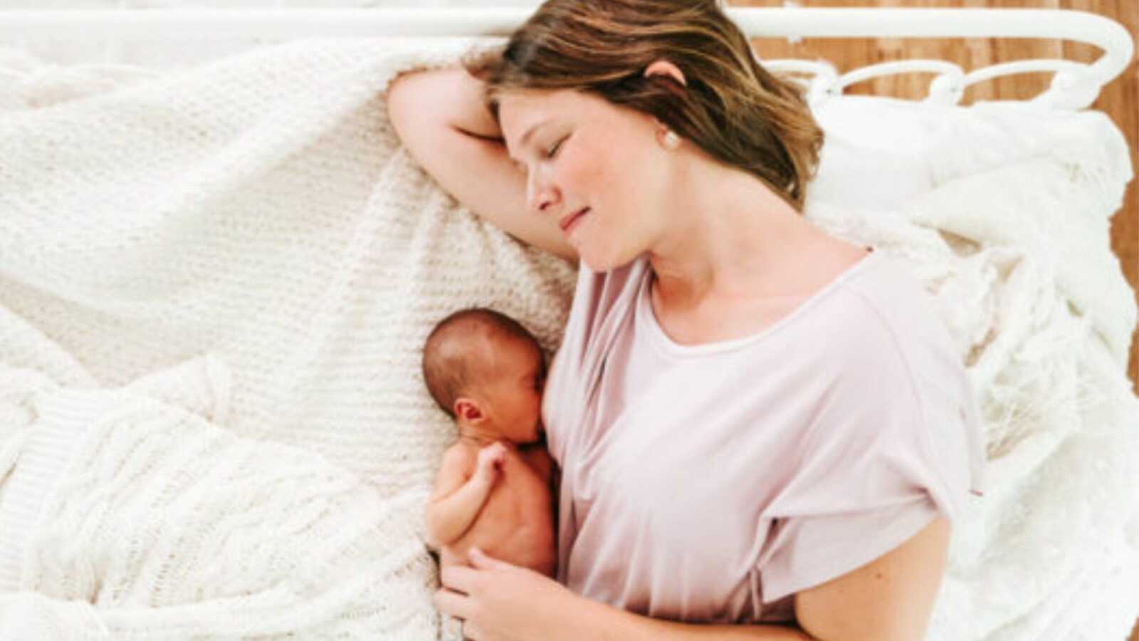 mom laying on the bed breastfeeding her child