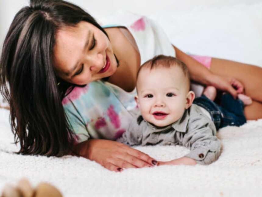 mom with her child on the bed smiling at him