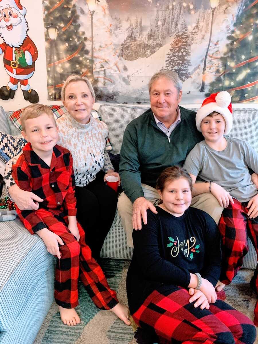Three children sit with their grandparents on Christmas morning