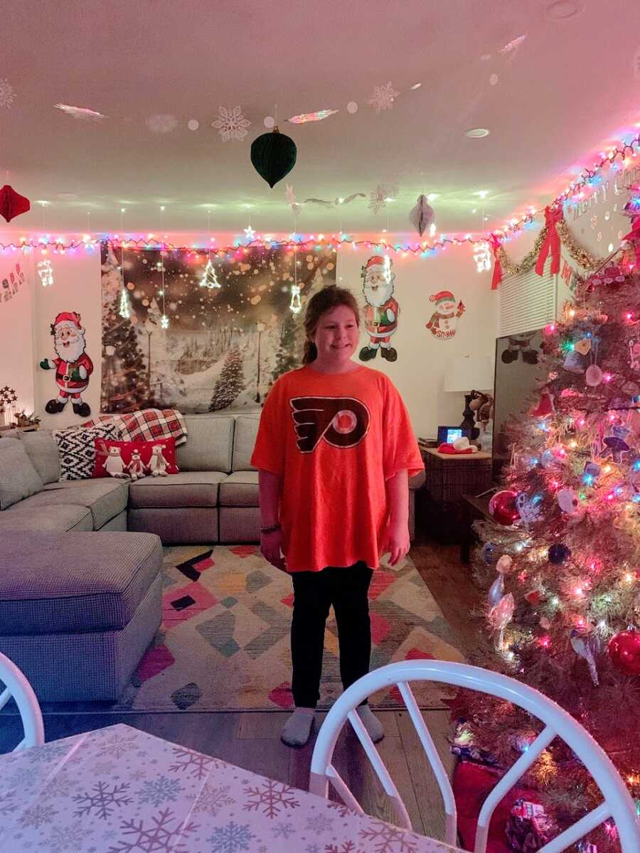 A young girl stands in a decorated living room