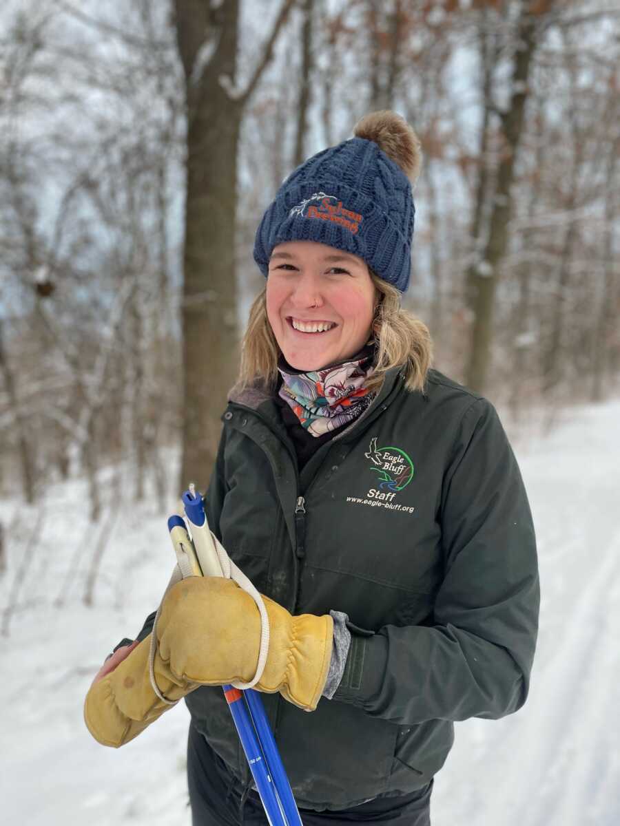 woman in the snow smiling bundled up