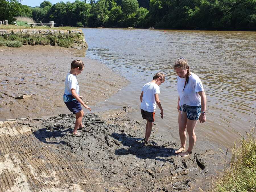 siblings playing in the mud