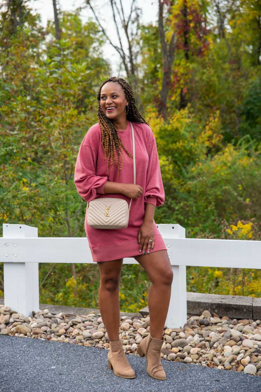 woman in a pink sweater dress looking beautiful against a green background