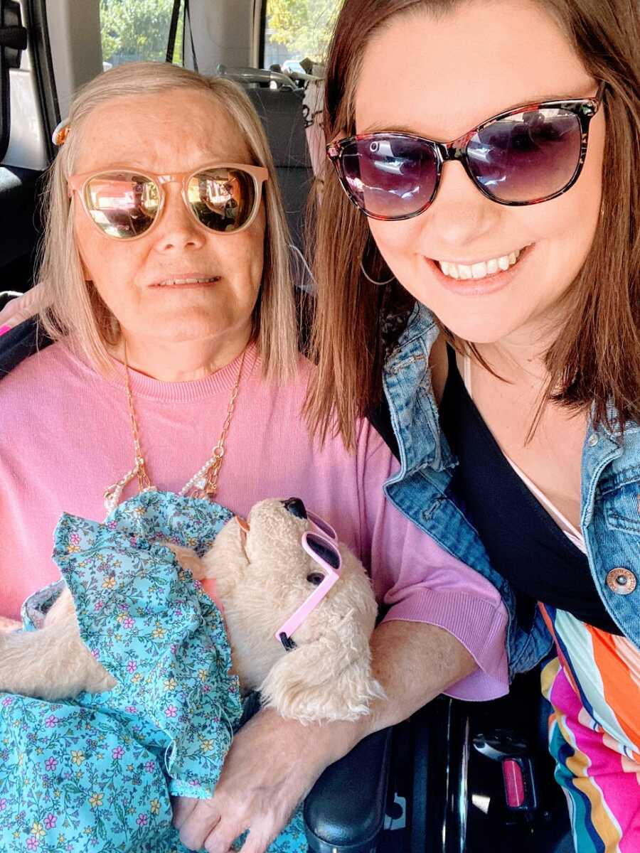 A mom and her daughter in the car wearing sunglasses