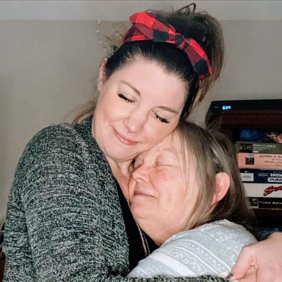 A daughter hugs her mom with dementia