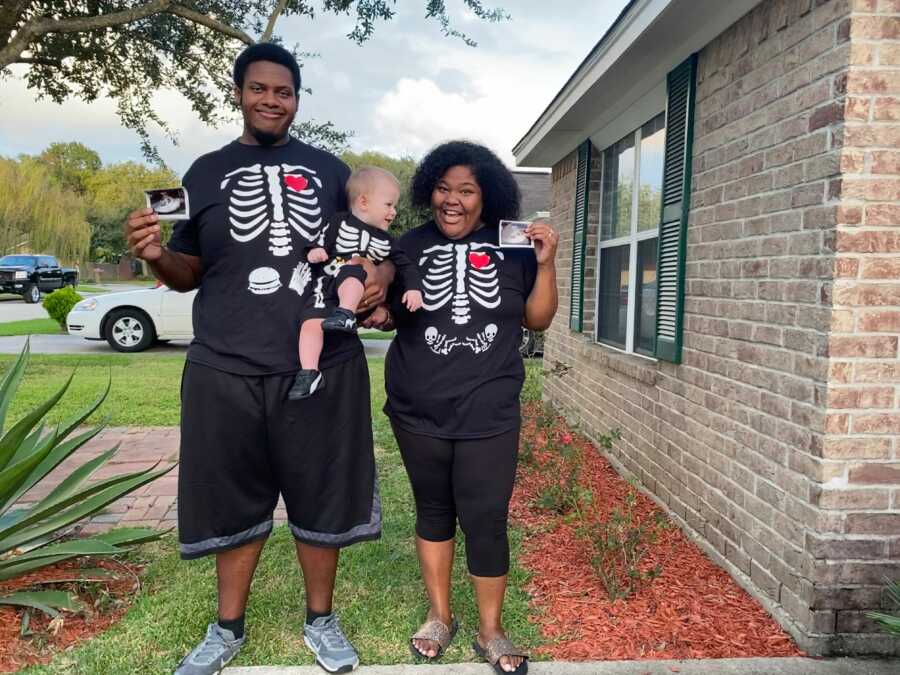 Couple hold up ultrasound pictures of twins.