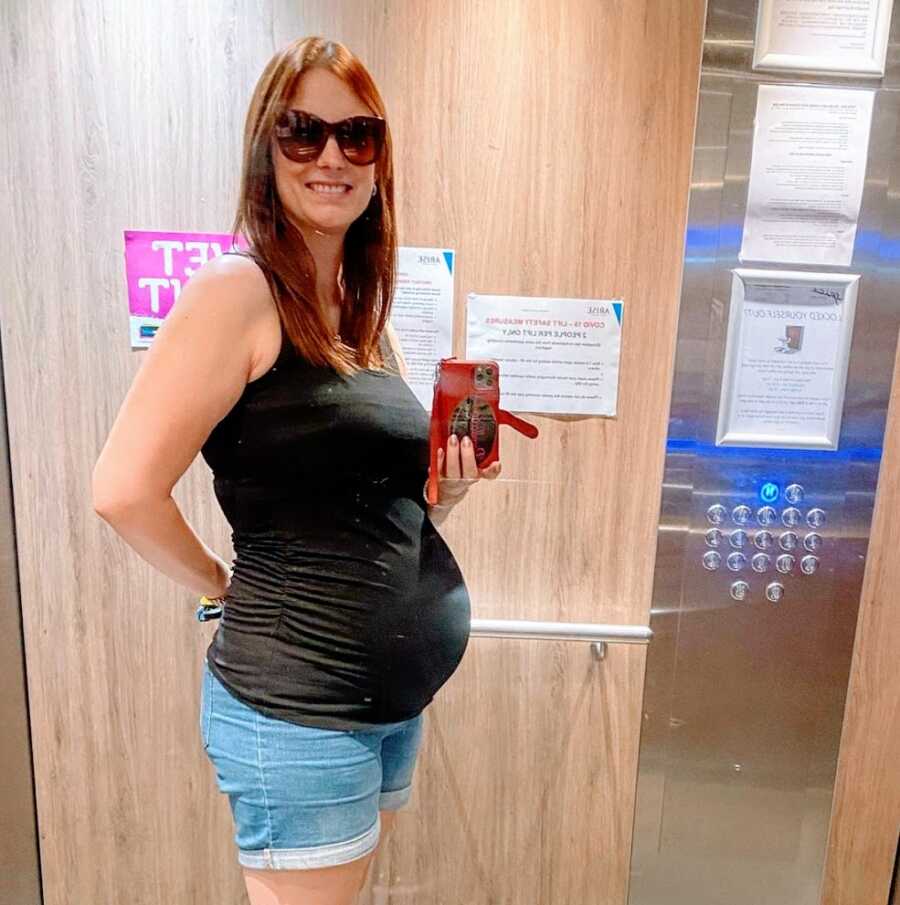 A pregnant single mom by choice stands in an elevator
