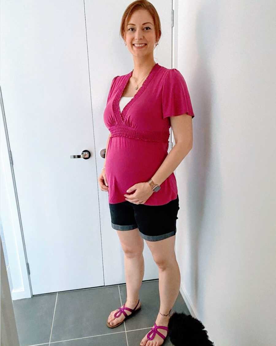 A pregnant woman wearing a pink shirt