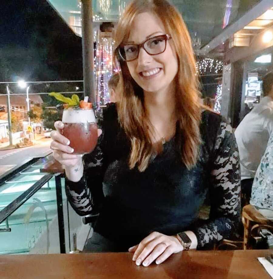 A hopeful single mom having a drink and wearing a black dress