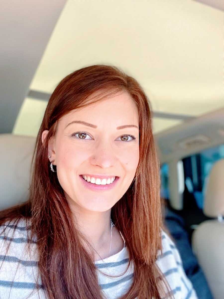 A hopeful mom with long hair in a car