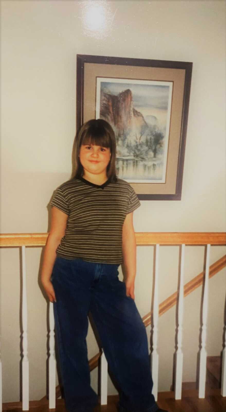 little girl standing by a railing posing