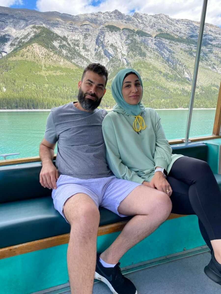 husband and wife sitting on a boat smiling at the camera