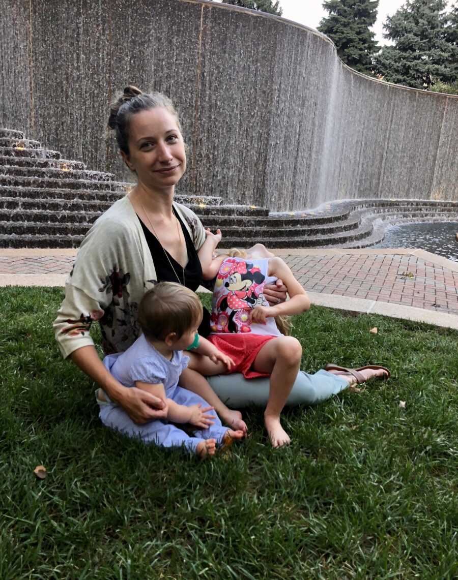 mom holding both of her kids by steps