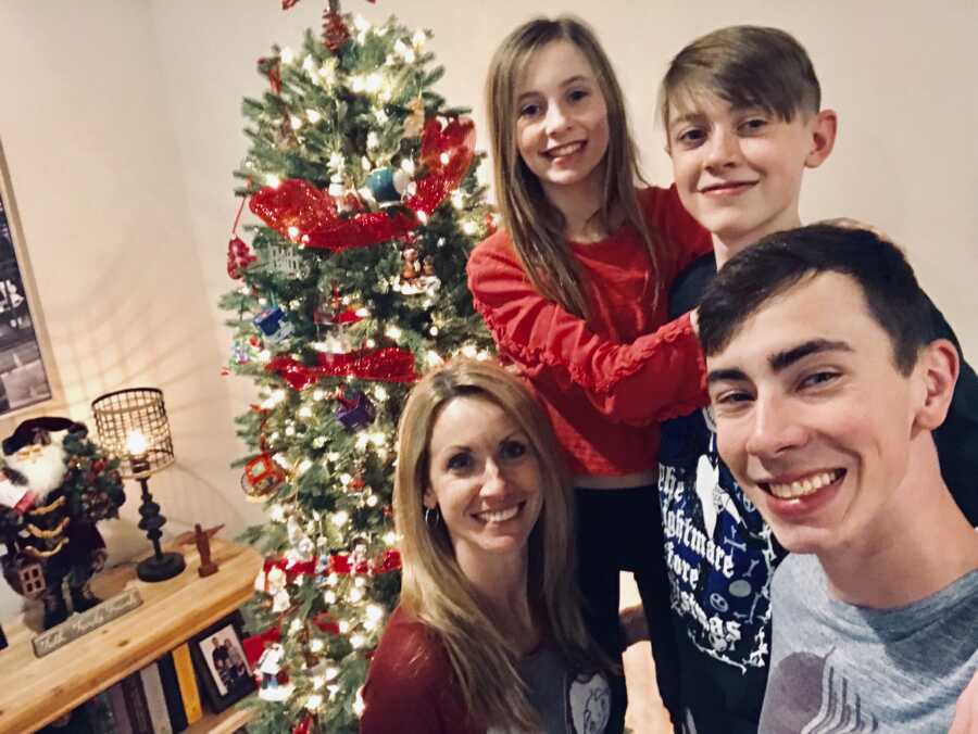 selfie of family around a christmas tree smiling