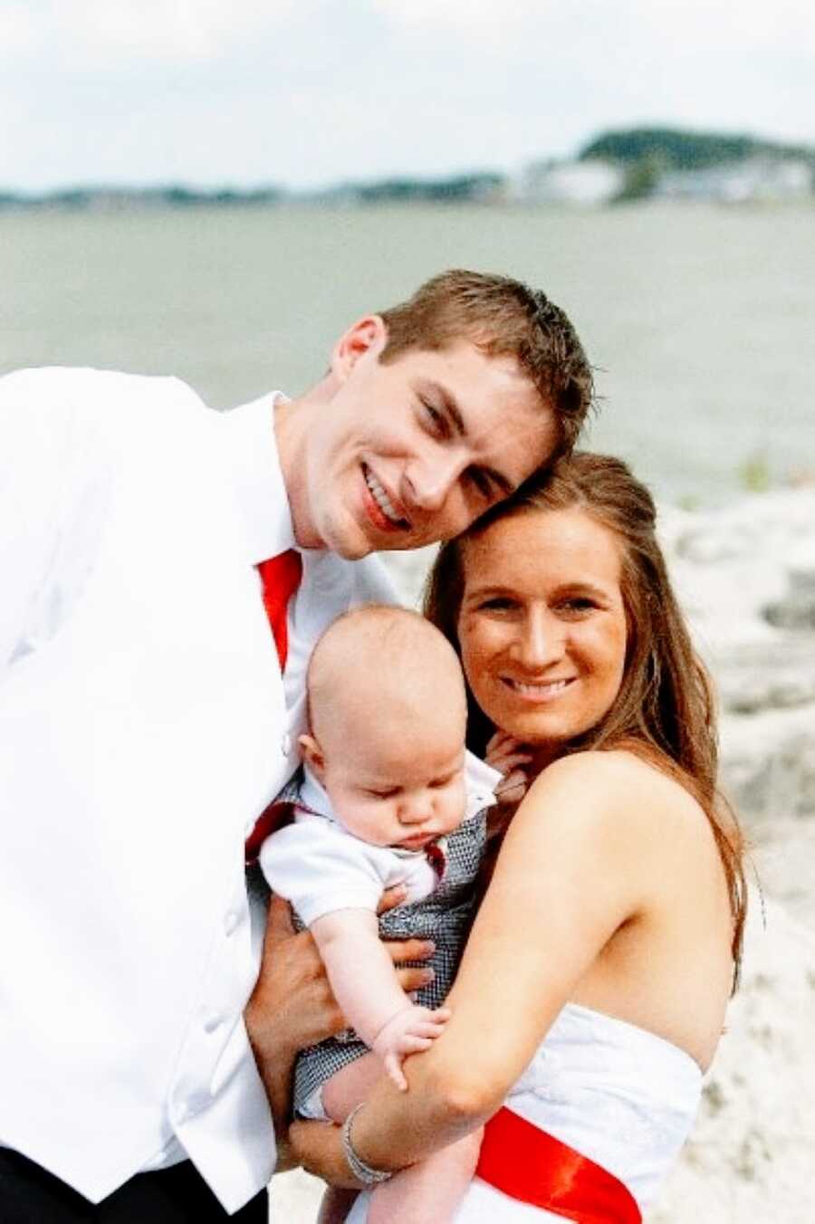 Newlyweds hold their son at their wedding