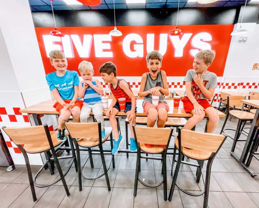 Mom takes photo of her five sons sitting in a Five Guys restaurant