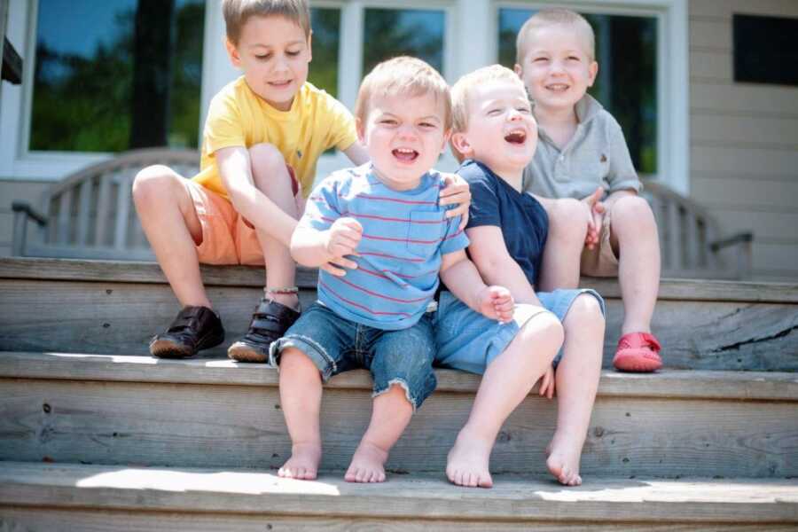 Mom takes a candid photo of her four sons handing out on the porch