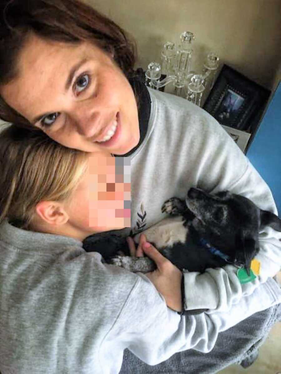 stepmom bonding with stepdaughter from a different country while holding dog