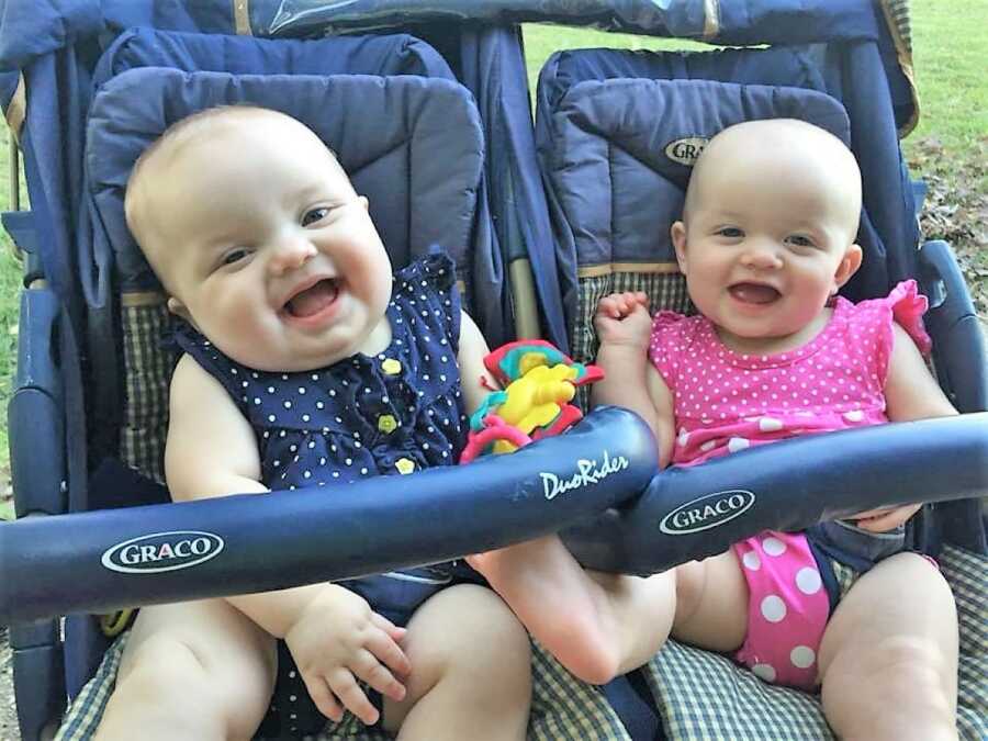 IVF twins sitting next to each other on their strollers and laughing