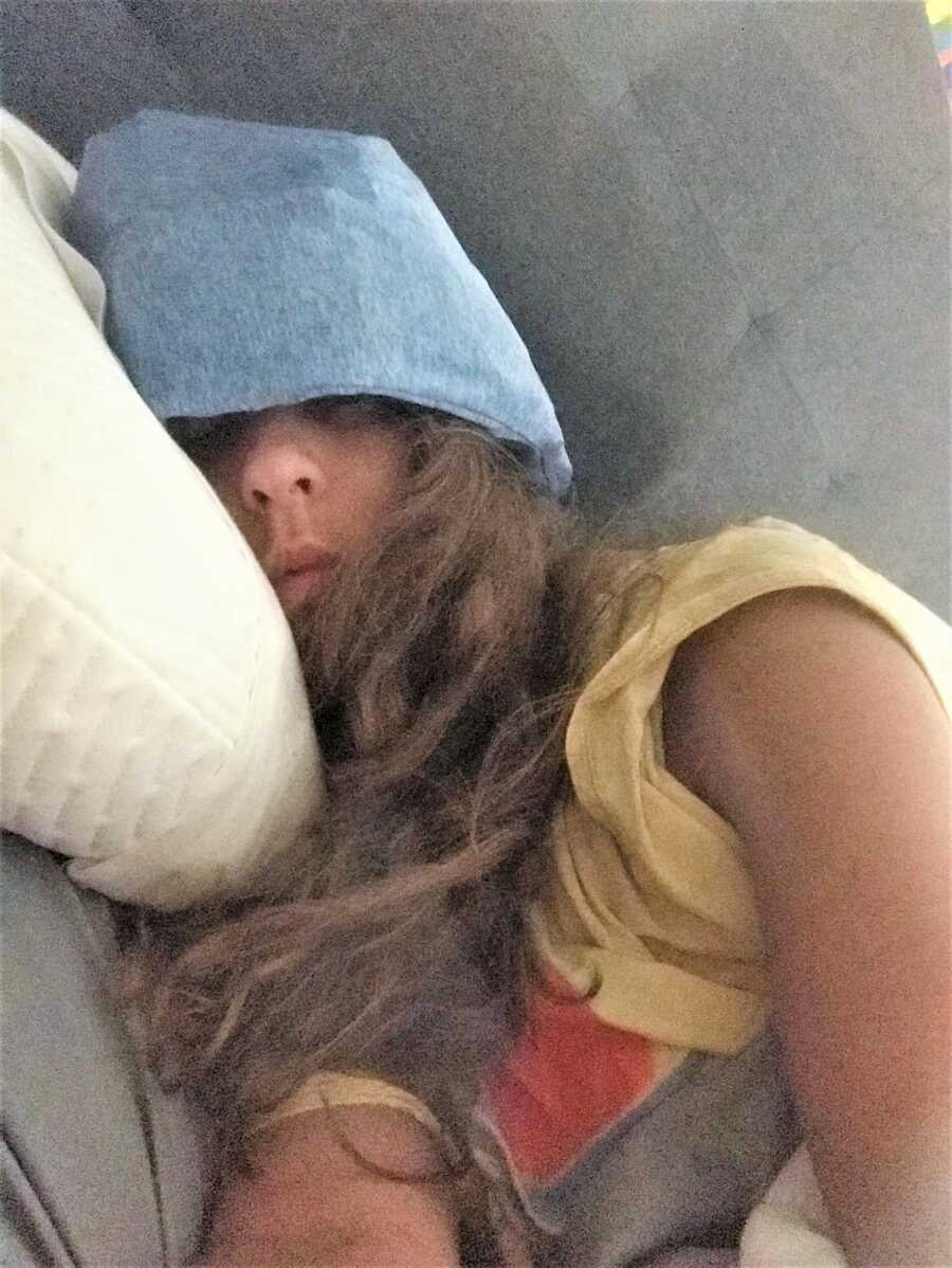 young woman battling chronic migraine wearing an Ice-Beanie on her head to deal with pain